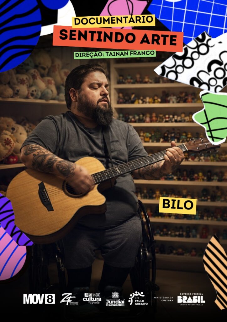 #PraCegoVer: Cartaz de divulgação do documentário “Sentindo Arte”. A imagem mistura fotografia e colagem gráfica, com formas abstratas coloridas nas bordas, em azul, rosa, verde, preto e branco. No centro, aparece um homem com barba, sentado em uma cadeira de rodas, tocando violão. Ele usa camiseta e bermuda cinzas, tem tatuagens nos braços e está em um ambiente interno, com prateleiras cheias de pequenos bonecos e pelúcias ao fundo. À direita, na parte inferior da imagem, há uma faixa amarela com o nome “Bilo” em letras pretas. Na parte superior, em faixas coloridas, está escrito “Documentário Sentindo Arte” e, abaixo, “Direção: Tainan Franco”. Na parte inferior, há uma faixa escura com os logotipos da MOV8, ZF Produções e Eventos, Cultura Jundiaí, Prefeitura de Jundiaí, Lei Paulo Gustavo, Ministério da Cultura e Governo Federal Brasil – União e Reconstrução.